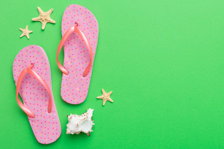 Flat lay composition with flip flops and seashell on colored background. Space for text view.の写真素材