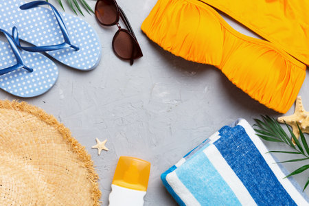 Woman swimwear and beach accessories flat lay top view on colored background Summer travel concept....