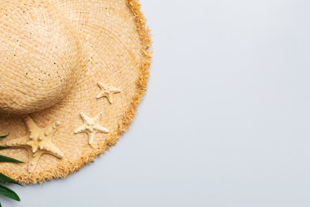 Summer holidays. Summer concept with straw hat and tropical leaf. Flat lay, top view, copy space.の写真素材