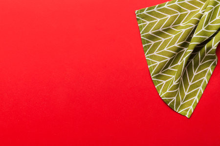 top view with green kitchen napkin isolated on table background. Folded cloth for mockup with copy...