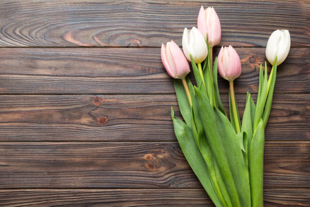 Bouquet of pink tulips on colored table background. Top view with copy space. waiting for spring. happy easter card. flat lay.の写真素材