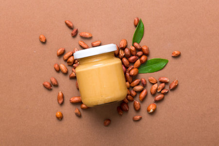 Bowl of peanut butter and peanuts on table background. top view with copyspace. Creamy peanut pasta in small bowl.の写真素材