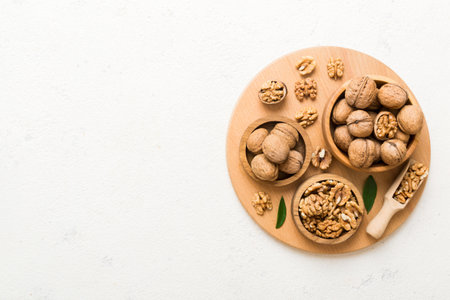 Walnut kernel halves, in a wooden bowl. Close-up, from above on colored background. Healthy eating Walnut concept. Super foods with copy space.の写真素材
