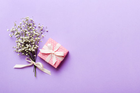 Gift or present box and flower gypsophila on light table top view. greeting card. Flat lay style with copy space.の写真素材