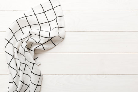 top view with white empty kitchen napkin isolated on table background. Folded cloth for mockup with...