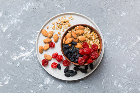 Cooking a wholesome breakfast. Granola with Various dried fruits and nuts in a bowl. The concept of a healthy dessert. Flat lay, top view with copy space.の写真素材