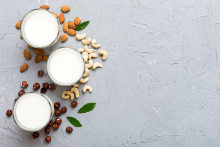 Set or collection of various vegan milk almond, cashew, on table background. Vegan plant based milk and ingredients, top view.の写真素材