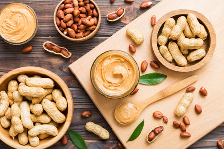 Bowl of peanut butter and peanuts on table background. top view with copyspace. Creamy peanut pasta...
