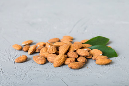 Close-up of Almond nuts with leaves on table background. top view. flat lay.の写真素材