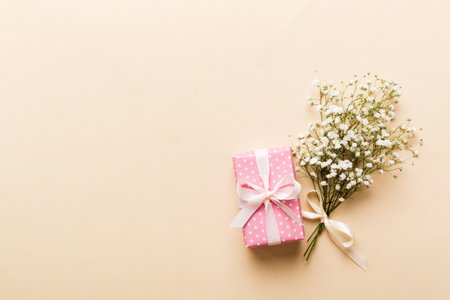 Gift or present box and flower gypsophila on light table top view. greeting card. Flat lay style with copy space.の写真素材