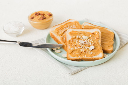 Peanut butter sandwiches or toasts on light table background.Breakfast. Vegetarian food. American...
