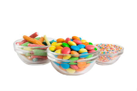 Multicolor small mixed colored chocolate coated candies in bowl, isolated on white.の写真素材