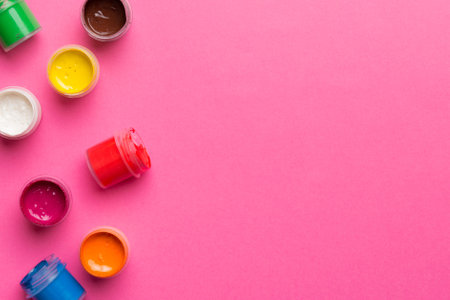 jars with gouache of different colors on Colored background. hobby painting. Top view with empty space. workplace for creativity. home teaching concept drawing.の写真素材