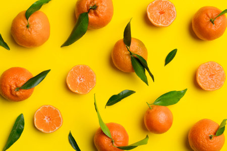 Many fresh ripe tangerines as colored background, top view. Elegant background of clementines and...