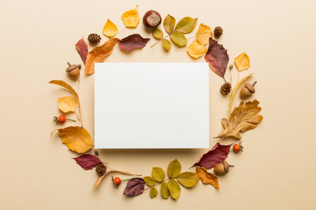 Autumn composition with paper blank and dried leaves on table. Flat lay, top view, copy space.