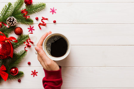 Woman holding cup of coffee. Woman hands holding a mug with hot coffee. Winter and Christmas time concept.の写真素材