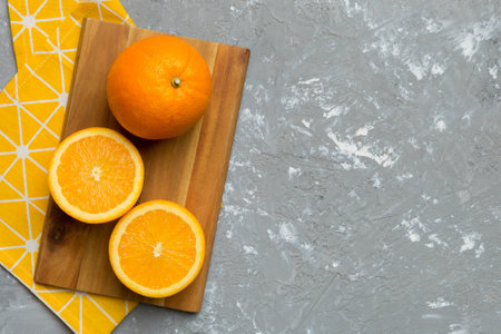 Fresh ripe oranges on cutting board on table. Top view flat lay.の写真素材