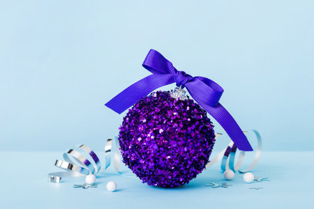 Christmas ball on colored background. decoration bauble with ribbon bow with copy space.の写真素材