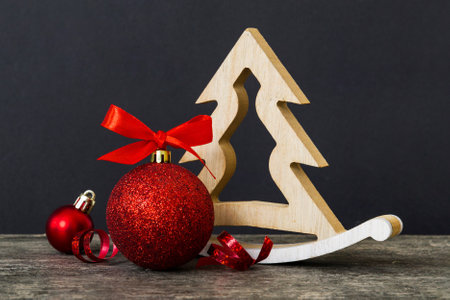 Christmas ball with decorative wooden tree on colored background. decoration bauble with ribbon bow with copy space.の写真素材