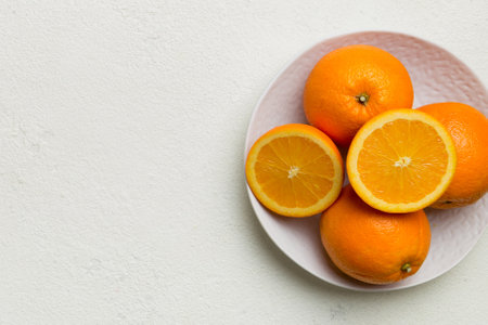 Flat lay of Fresh orange fruit with sliced in plate on Colored background. Top view with copy space.の写真素材
