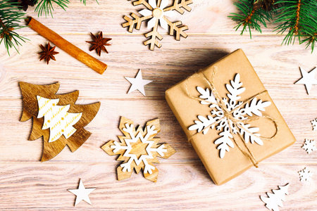 gift box in craft paper with Christmas decoration, twine rope, concept background, top view on wood table surface. Christmas ornaments and presents border with snowflakes and stars. Toned.の写真素材