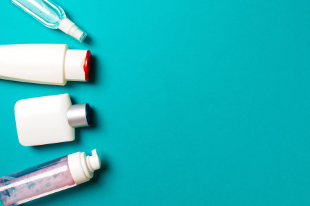 Set of White Cosmetic containers isolated on colored background, top view with copy space. Group of...