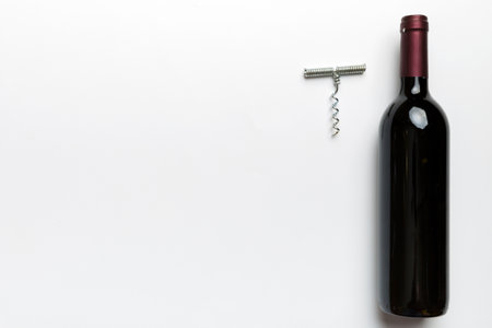One Bottle of red wine with corkscrew on colored table. Flat lay, top view wth copy space.の写真素材