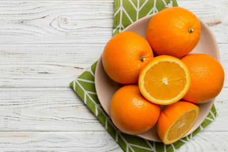 Flat lay of Fresh orange fruit with sliced in plate on Colored background. Top view with copy space.の写真素材