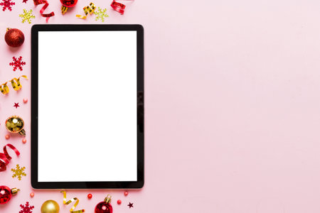 Christmas online shopping from home tablet pc with blank white display top view. Tablet with copy space on colored background with Christmas decorations balls,. Winter holidays sales background.の写真素材