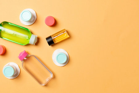 Set of travel size cosmetic bottles on colored background. Flat lay of cream jars. Top view of bodycare style concept.の写真素材