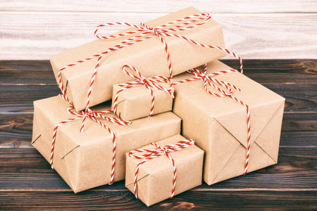 parcels boxes with kraft paper, on wooden table on gray background. Toned.