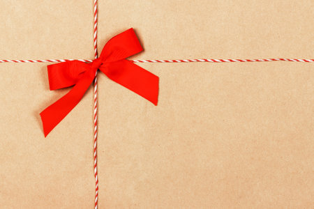 kraft paper gift box with ribbon bow from above, textured backgroundの写真素材