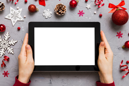 Christmas online shopping from home, female hands holding tablet pc with blank white display top...