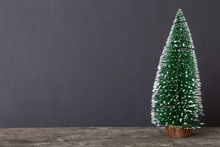 One small Christmas tree on colored background. new year decoration with copy space.