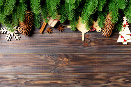 Top view of frame made of fir tree branches and holiday decorations on wooden background. Christmas concept with empty space for your design.の写真素材