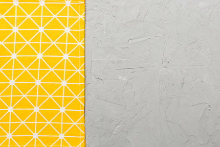 top view with yellow empty kitchen napkin isolated on table background. Folded cloth for mockup with...