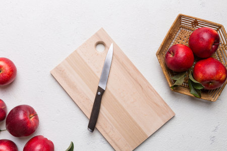 Fresh red apples with green leaves on table. cutting board with knife. top view.の写真素材