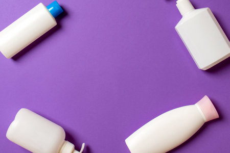 Set of White Cosmetic containers isolated on colored background, top view with copy space. Group of plastic bodycare bottle containers with empty space for you design.の写真素材