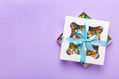 Box with sweet chocolate candies on color background, Various candy sweets. Valentines day gift box....