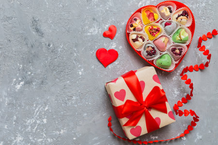 Valentine day composition: sweet candy, with gift boxes with and red felt hearts, photo bow template, background. Top View with copy space.の写真素材