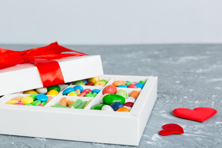 Valentine day composition: sweet candy, with gift boxes with bow and red felt hearts, photo template, background. Perspective with copy space.の写真素材