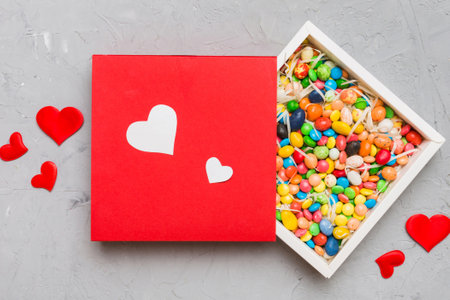Valentine day composition: sweet candy, with gift boxes with and red felt hearts, photo bow...