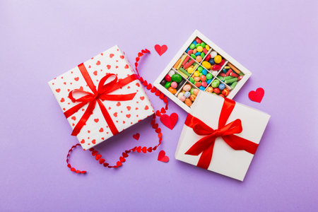 Valentine day composition: sweet candy, with gift boxes with and red felt hearts, photo bow template, background. Top View with copy space.の写真素材