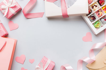 top view photo of st valentine's day decor shopping, bag, envelope, gift, box, candy and red heart on colored background with empty space. frame background.の写真素材