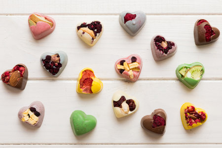 chocolate sweets in the form of a heart with fruits and nuts on a colored background. top view with space for text, holiday concept.の写真素材
