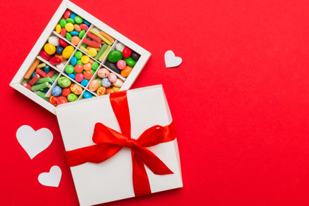 Valentine day composition: sweet candy, with gift boxes with and red felt hearts, photo bow template, background. Top View with copy space.の写真素材