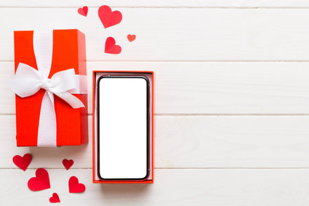 Opened gift box with ribbon and phone on color background, top view. Blank open box packaging mockup , Template for your design - branding mockup.
