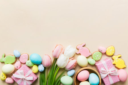 Easter frame with eggs, gift box and tulip on a colored background. The minimal concept. Top view Happy Easter composition. Card with a copy space of the place for the text.の写真素材