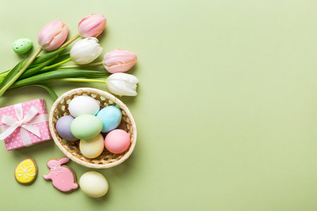 Easter frame with eggs, gift box and tulip on a colored background. The minimal concept. Top view Happy Easter composition. Card with a copy space of the place for the text.の写真素材