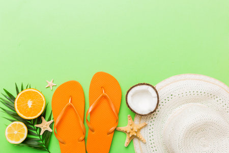 Top view of various seashells placed near colorful fruit and stylish summer accessories on table background. Summer concept. Flat lay. Top view with copy space for text.の写真素材